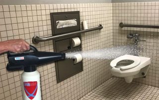 spraying disinfecting public restroom